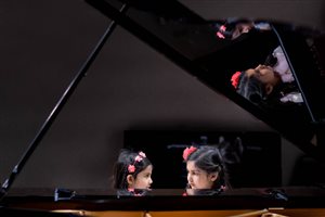 Sisters playing a duet at the Formal Recital at the Steinway Gallery STL